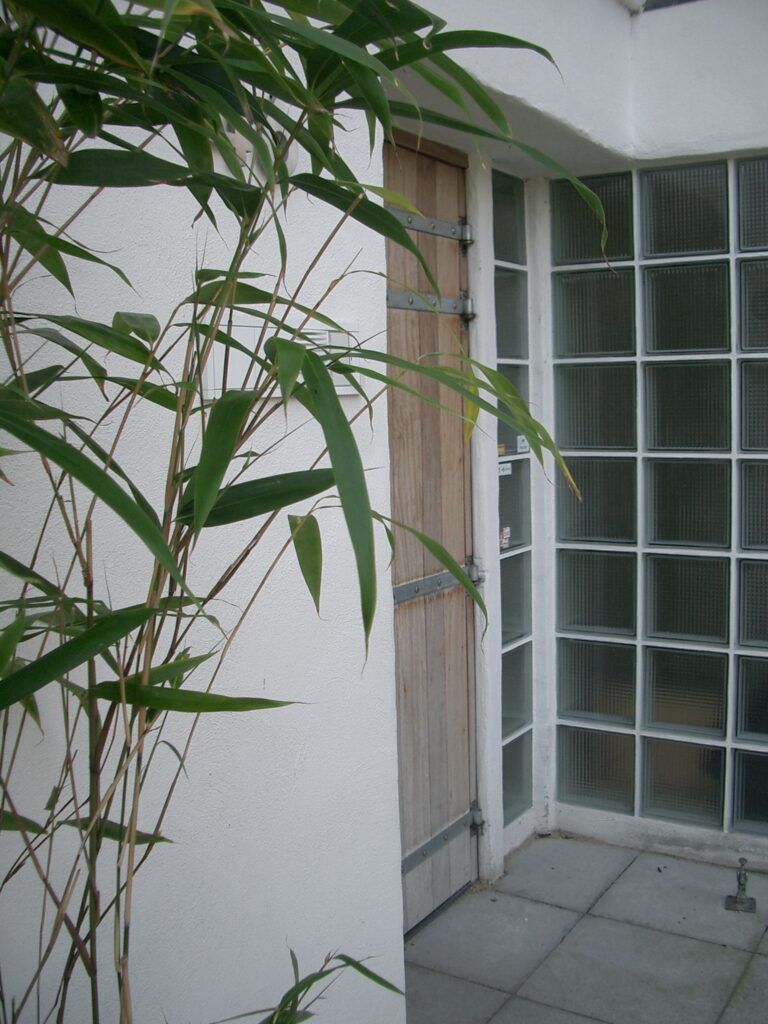 Carry-design: bamboe bij kantoorentree, met houten deur, glasblokken en stucwerk