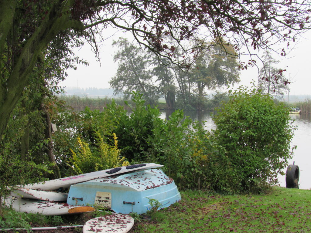 OUDE SITUATIE: bootopslag op gazon bij water met daarnaast een rommelige groenstrook