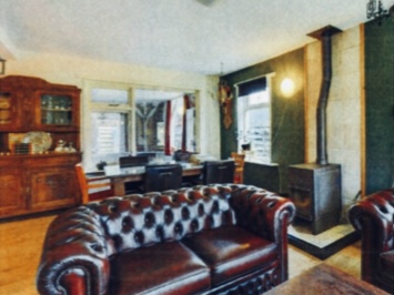 OUD woonkamer met zware donkere meubels en donkergroene wand